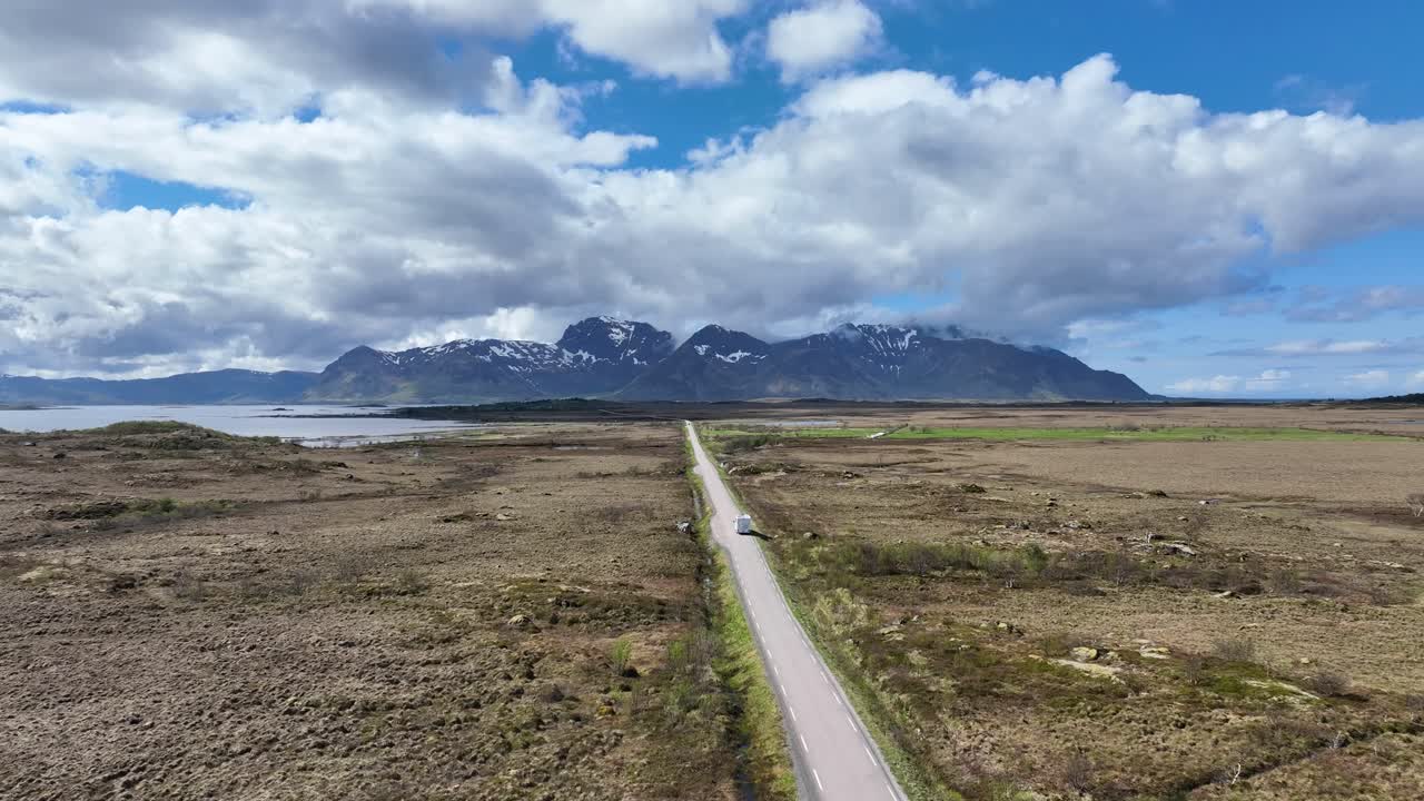 Aerial of motor home traveling straight road through Lofoten islands in Norway, symbolizing summer tourism, exploration, overcrowding