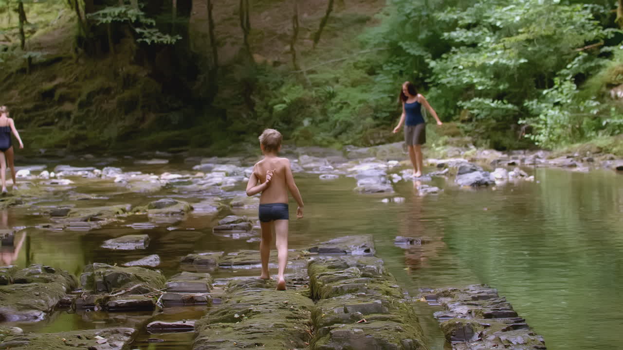 Famille marchant sur des rochers dans une rivière