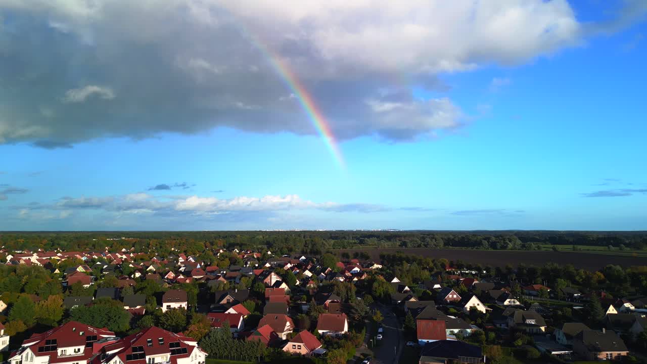 arco iris de una nube blanca sobre un pueblo