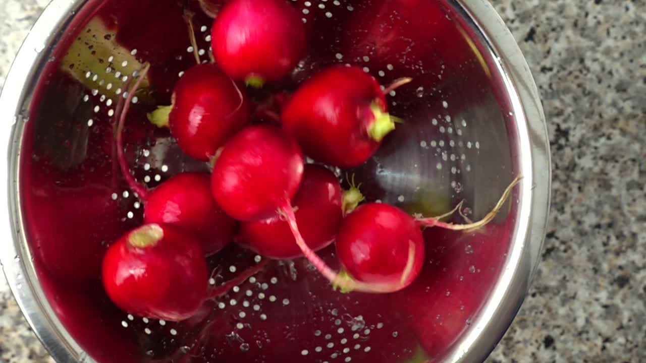 Tossing of a garden radish in a colander. Slow motion