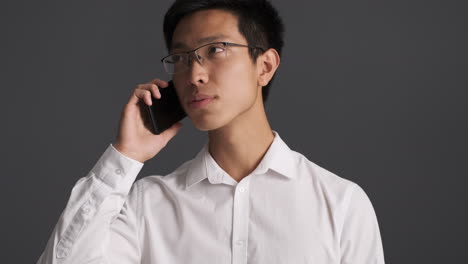 un hombre asiático molesto llamando por teléfono.