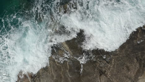 Aerial-Overhead-Top-Down-Birds-Eye-View-of-Generic-Ocean-Waves-crashing-on-Rocks