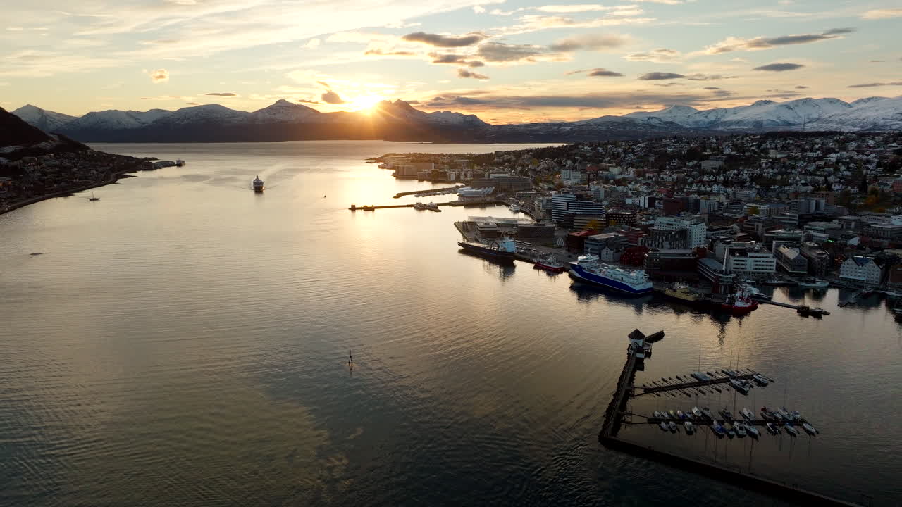 Sunset aerial view early winter over Tromso city with Hurtigruten ship docking