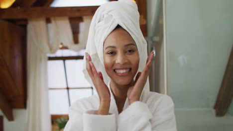 Portrait-of-mixed-race-woman-wearing-bathrobe-looking-at-camera