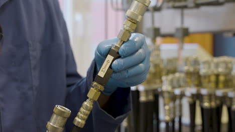 professor holding and demonstrating different hydraulic hoses used in a hydraulics lab