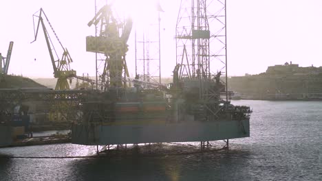 port structure and ship cranes in the water of malta's famous three cities