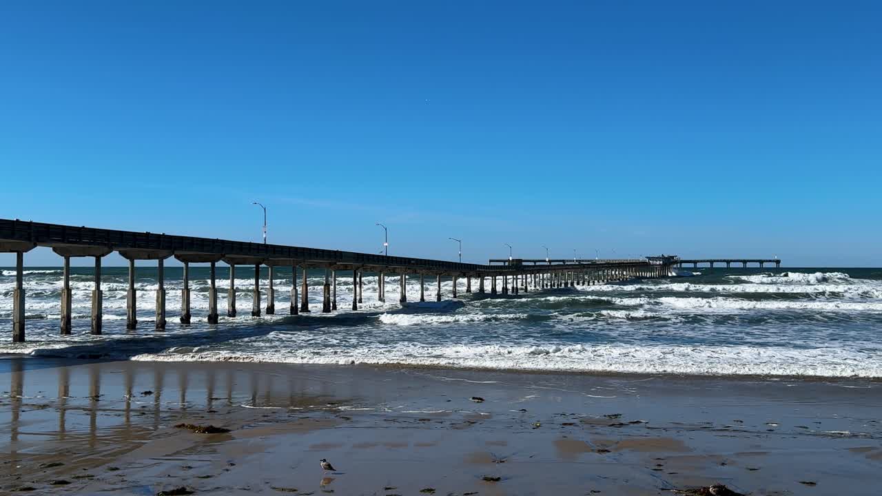 el muelle de la playa del océano en el sur de california durante la marea real con olas que golpean el fondo del muelle