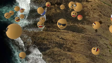 digital composition of multiple face emojis floating against aerial view of the beach