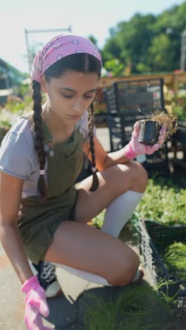 adolescente comprobando las plantas en un centro de jardinería