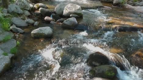 Eine-Nahaufnahme-In-Der-Nähe-Der-Oberfläche,-Die-Einen-Fluss-Mit-Vielen-Steinen-Hinaufführt