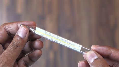 person holding a glass thermometer