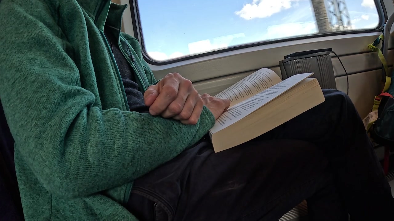 Video of train passenger reading a book.