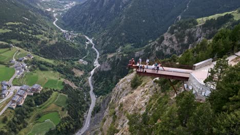 Mirador-Colgante-En-Una-Montaña-En-Andorra,-Con-Una-Estatua-Y-Gente-Moviéndose-Y-La-Ciudad-Se-Ve-Al-Fondo