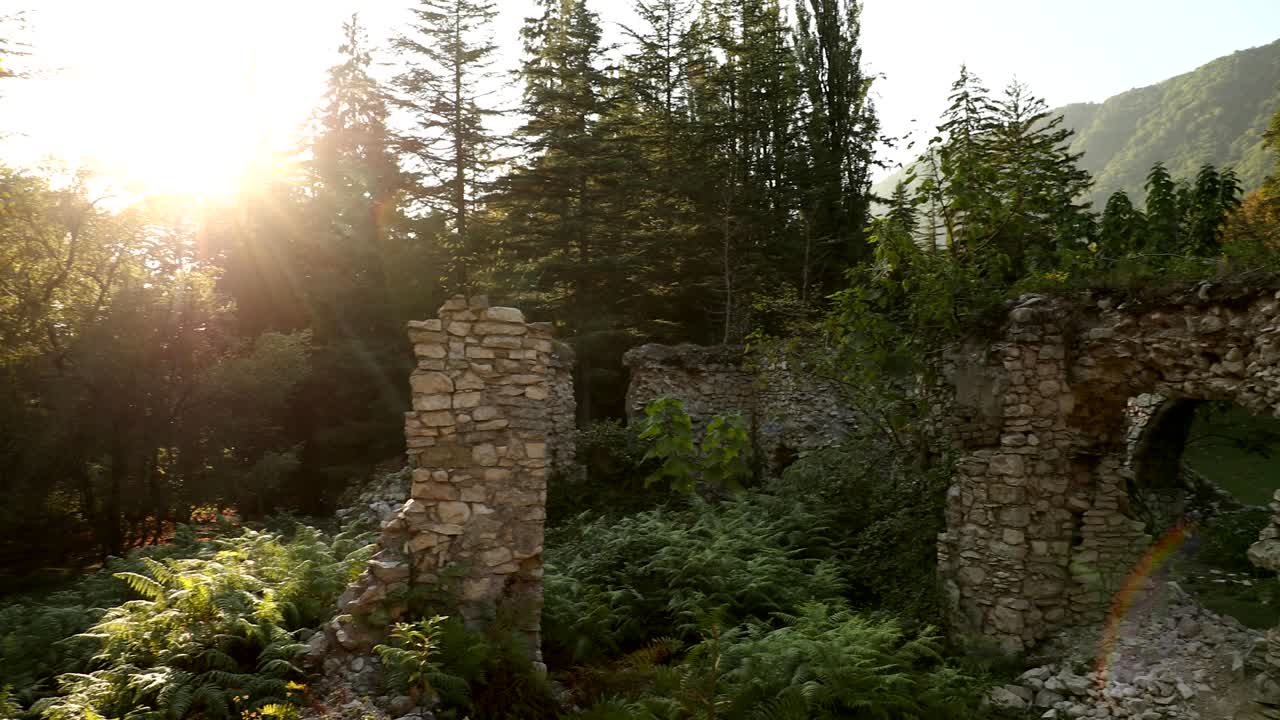restos del palacio de los príncipes del siglo xviii en el parque dadiani en el cañón okatse al atardecer o al amanecer. sol sol con luz natural y rayos de sol a través de los árboles