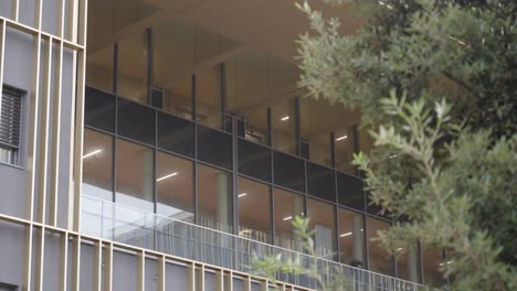 movimiento lento revelando disparo de grandes ventanas de vidrio en la fachada de una universidad