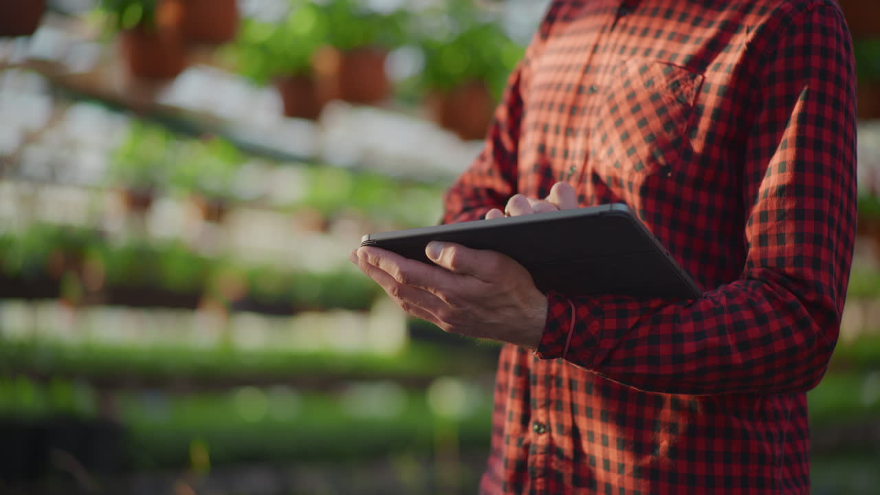 Gardener Using Digital Tablet in Greenhouse