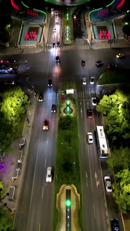 vertical aerial footage of city center of bucharest, at night. view of unirii bulevard. water fountain. capital city of romania. famous travel destination. camera tilt up. night traffic.