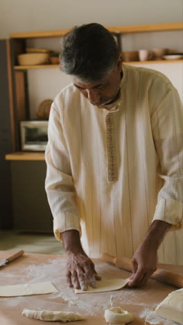 indian man making flatbread in his kitchen