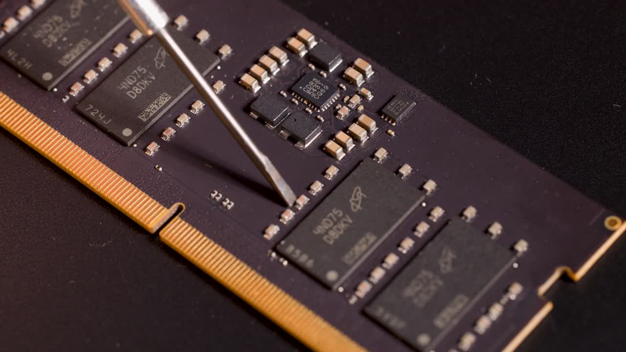Macro view of metal tool indicating microchip on memory module, warm lighting, steady close-up shot