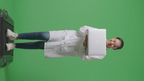 full body of asian female doctor with stethoscope using a laptop while walking on green screen background in the hospital