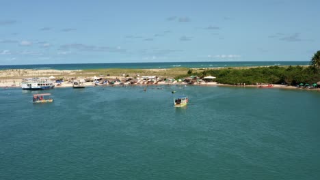 dolly en toma aérea de drones de la hermosa playa turística tropical de restinga donde el gran río curimataú se encuentra con el mar cerca de barra do cunhaú en rio grande do norte, brasil en un día de verano