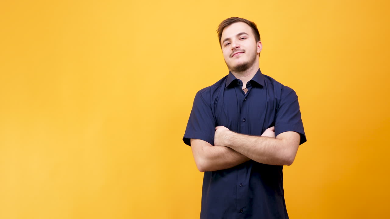 Confident man with arms crossed on yellow background