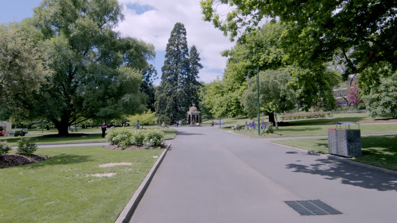 camino en medio del parque de la ciudad con árboles sombreados