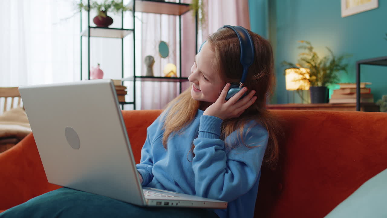 Preteen child girl in headphones using laptop listens to music or lesson distance online learning