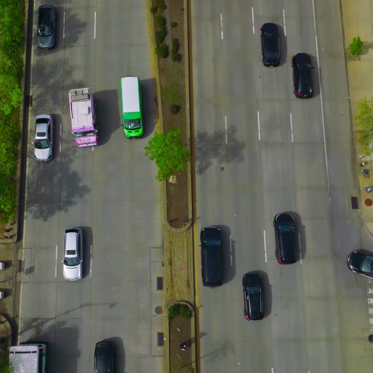 Wide road with several lanes with numerous cars driving on it. Drone footage along the busy motorway in New York