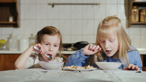 two little girls 5 and 7 years with an appetite eat soup 4k video