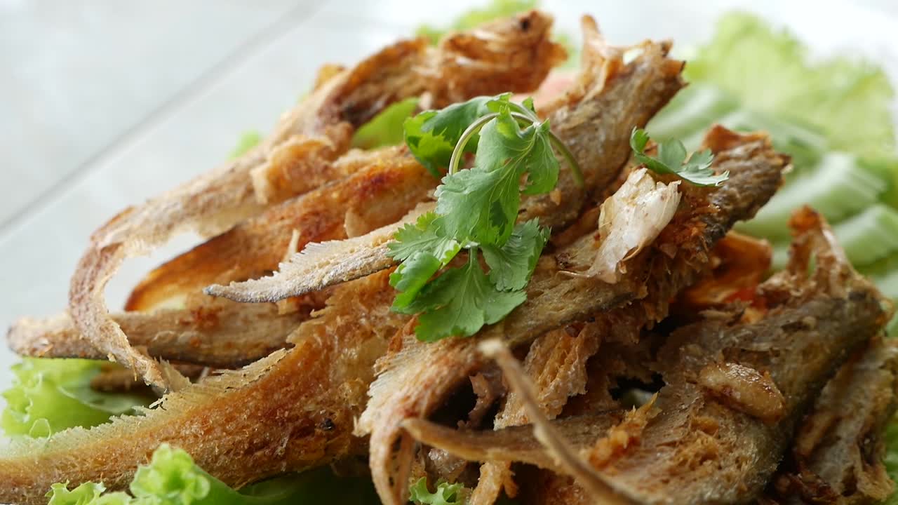imágenes de primer plano de pescado de río frito crujiente y ajo, deliciosa comida asiática
