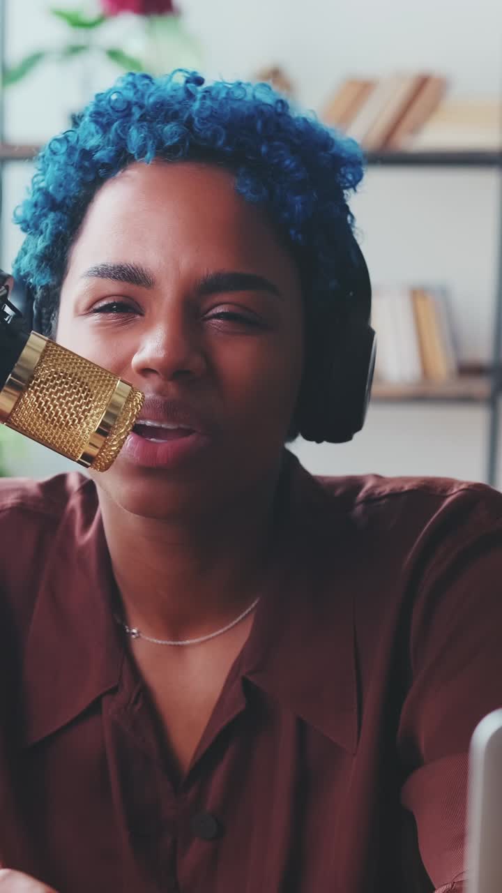 Ung, positiv afroamerikansk kvinde speaker i radio taler i mikrofon