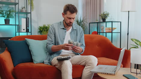 hombre rico feliz contando dinero en efectivo y el uso de la calculadora, calcular los ingresos domésticos ganancias en el hogar