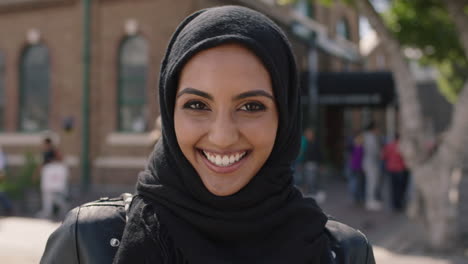 portrait of young beautiful muslim woman wearing hajib headscarf laughing happy enjoying life in city