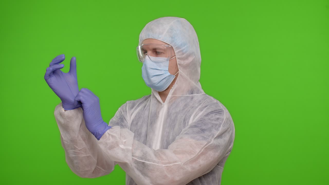 hombre con equipo de protección poniéndose guantes