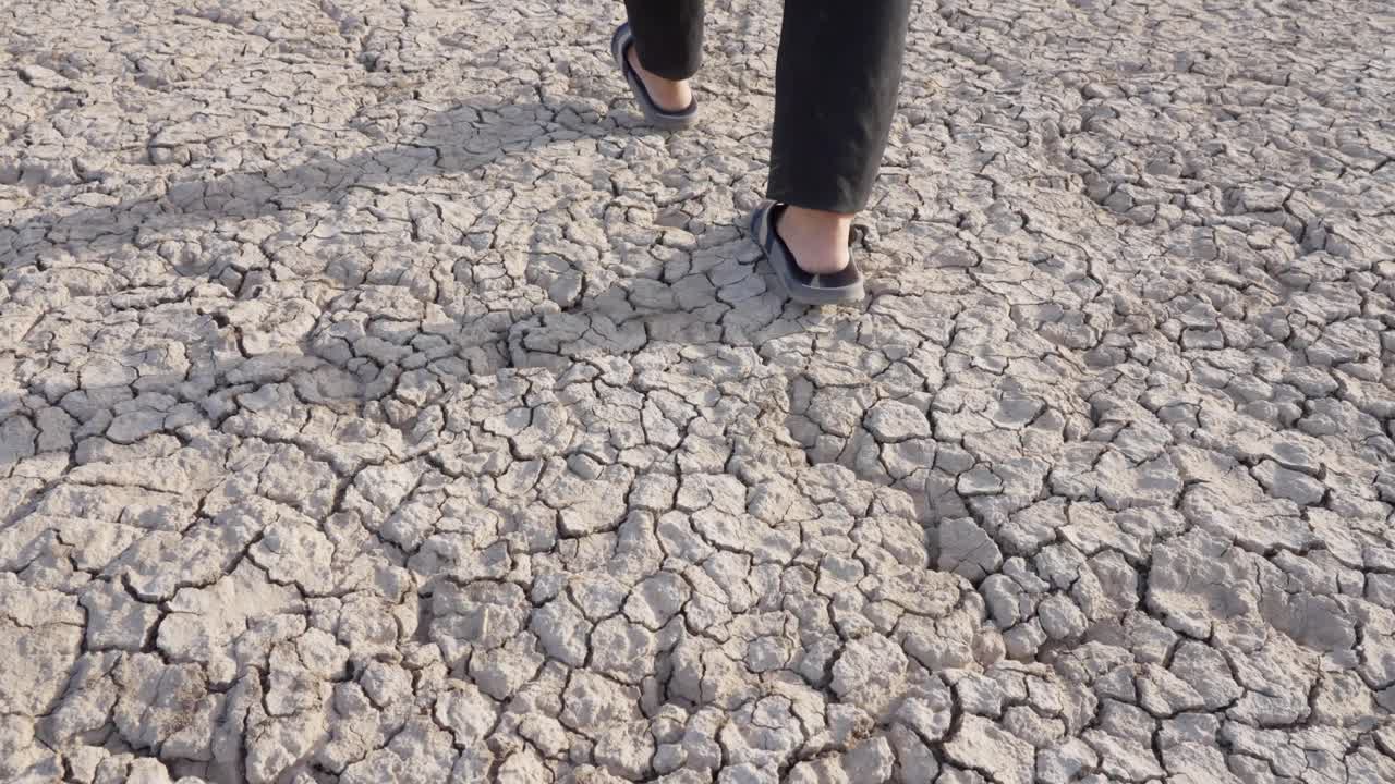 매우 건조한 땅에서 는 플립 플롭을 입은 남성 발의 손잡이 높은 각도