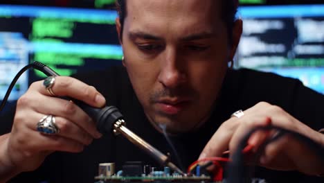close-up of a skilled technician engaged in detailed soldering work on a circuit board in a tech environment with low lighting and computer code in the background