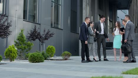 Freelancers colleagues drinking coffee in business clothes standing outdoors near office building. Business people having a coffee break. Business concept. Business person. Employment