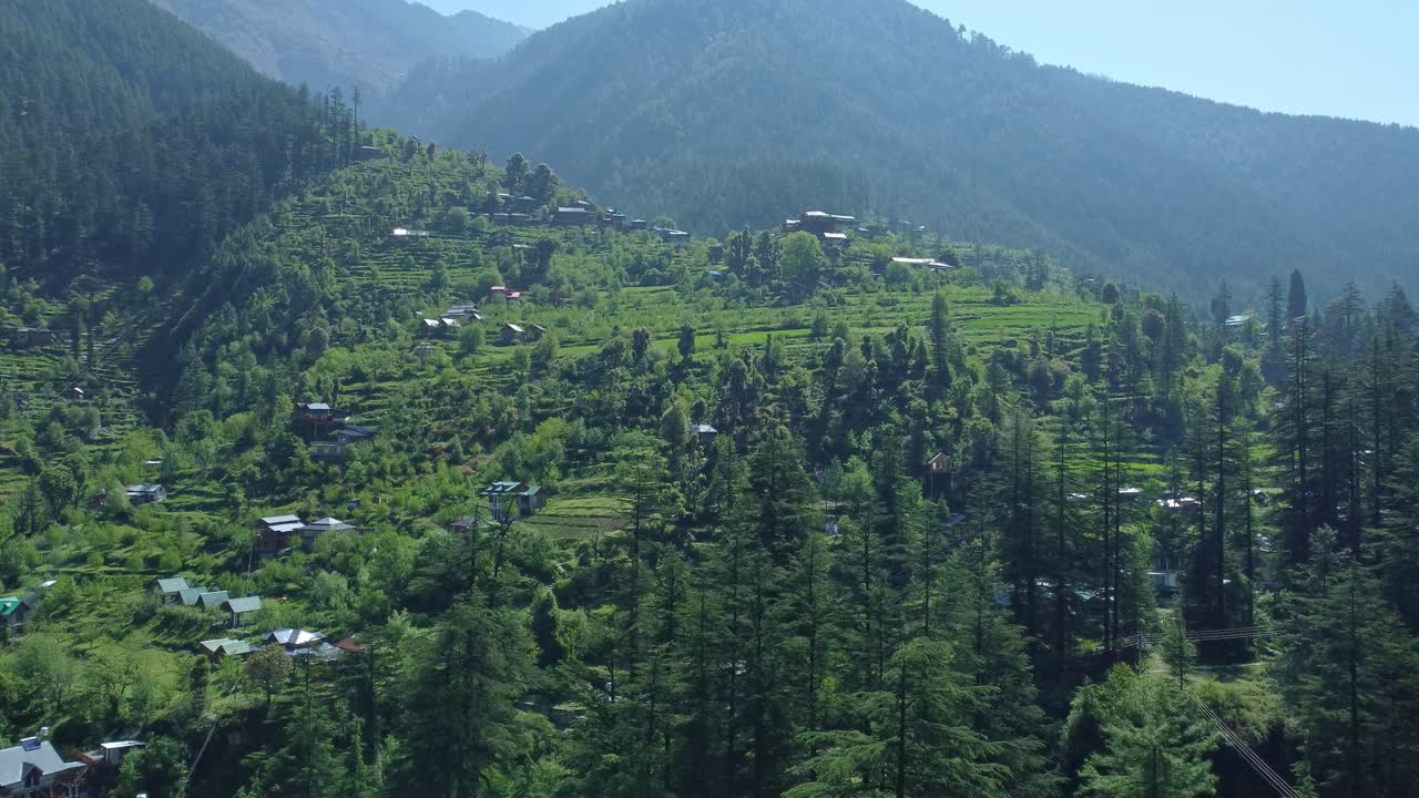 Aerial view short of Jibhi Himachal Pradesh in India. Houses and trees in the mountainous area. Faguli festival is one of the biggest festival in Jibhi. The traditional houses here have stone roofs.