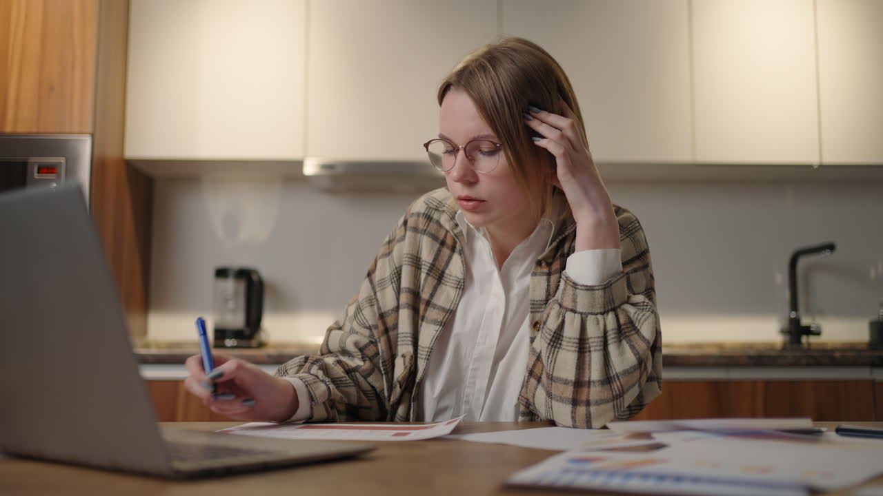 una mujer con gafas estudiante de aprendizaje a distancia en casa para realizar una tarea en economía