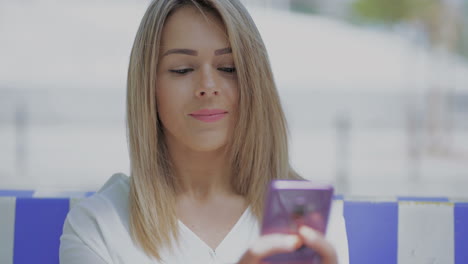 Girl-using-smartphone-and-smiling-at-camera