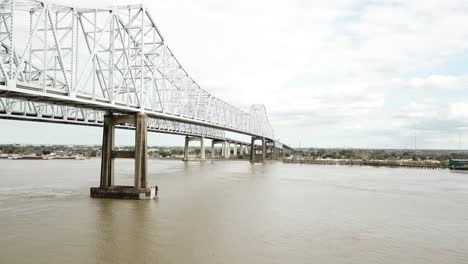 Muddy-Water-Of-Mississippi-River-With-Crescent-City-Connection,-Twin-Cantilever-Bridge-Over-New-Orleans,-USA