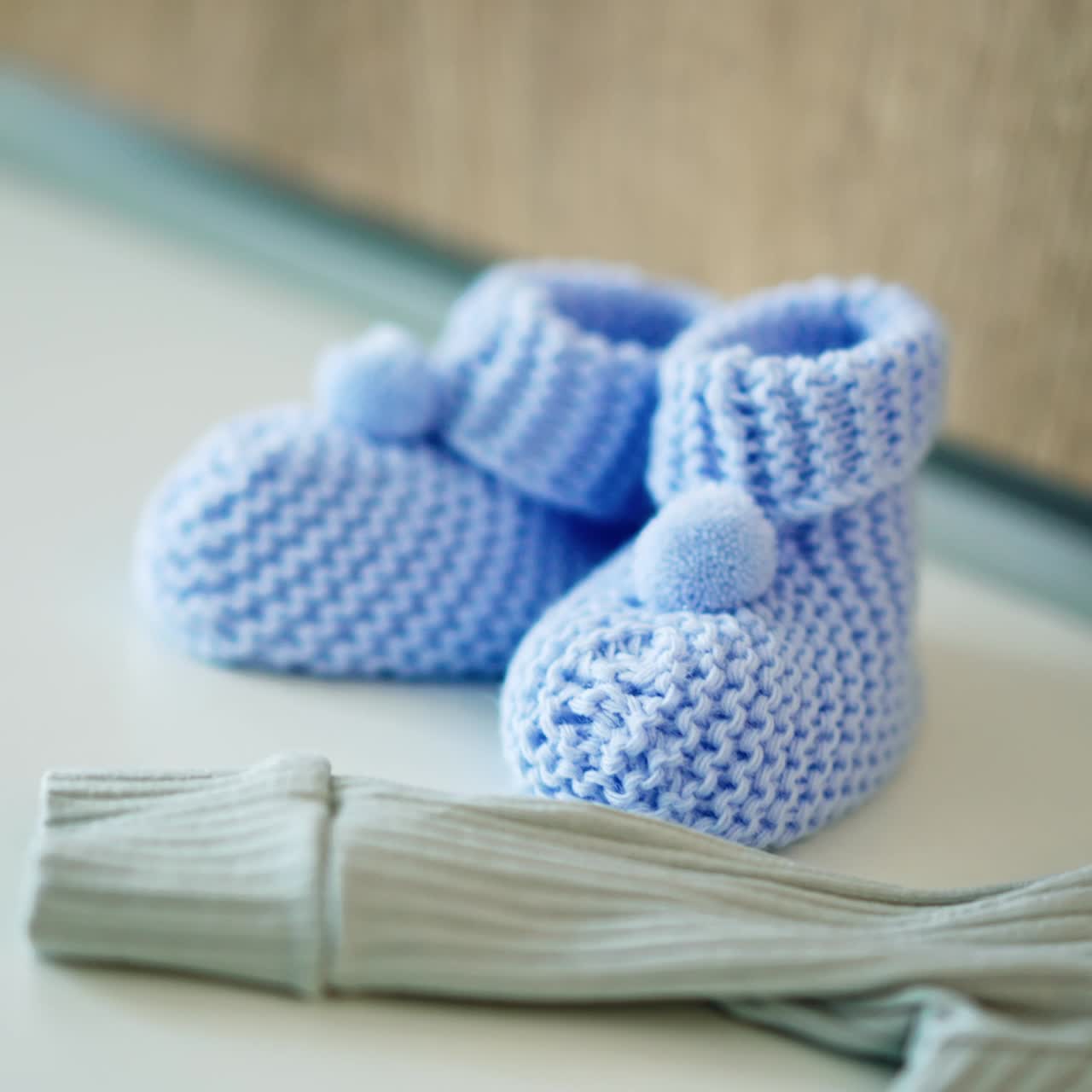 Blue knitted boots and clothes prepared for the newborn baby. Little boy expectation. Close up