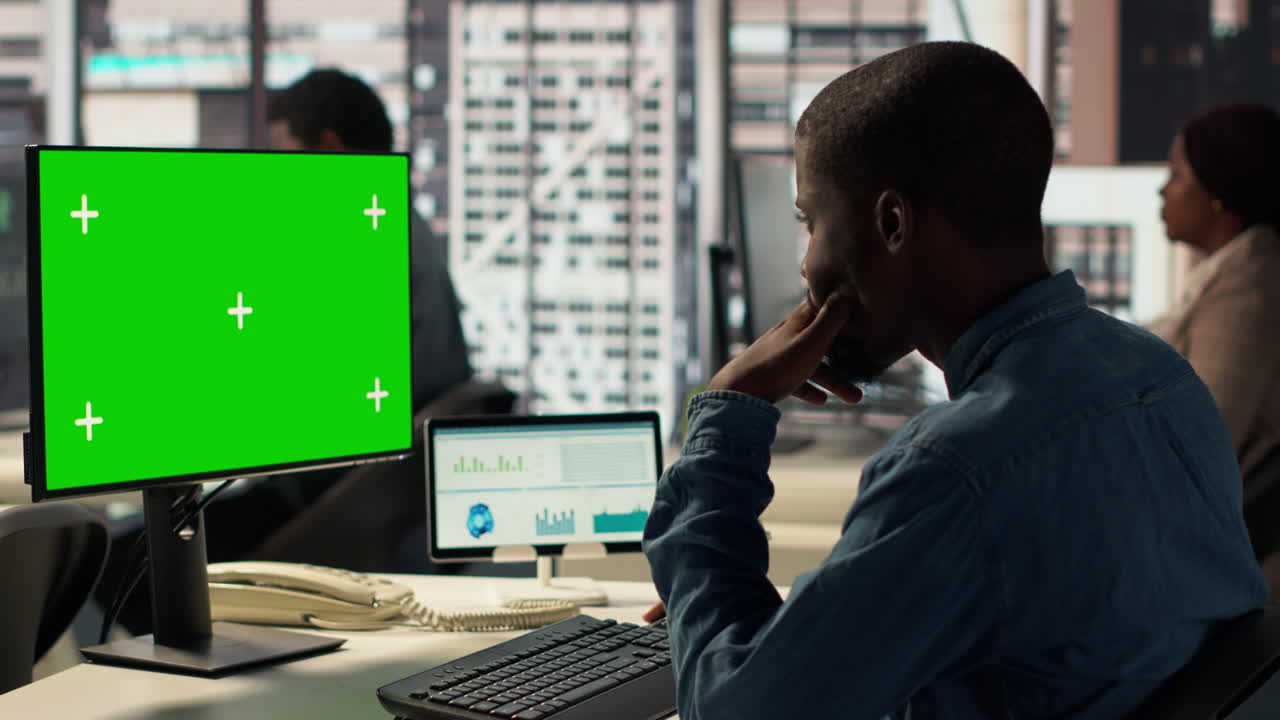 uomo d'affari che lavora su un computer con un monitor a schermo verde