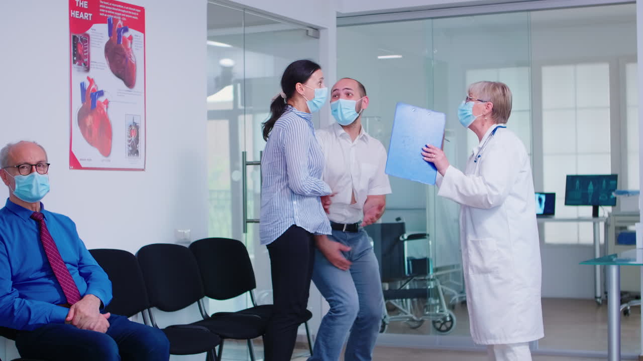 Pareja joven emocionada recibiendo buenas noticias del médico