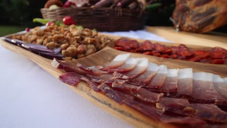 sliced bacon, sausage and greaves served on a platter. smoked, dried pork meat products