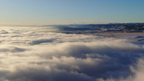 high windmill turning above the fog in the nature close to denver