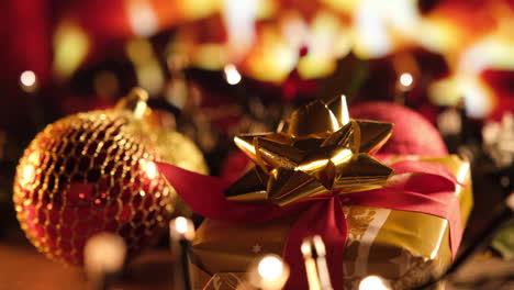 regalo de navidad dorado y decoración de bolas rojas frente a la chimenea en el salón de casa