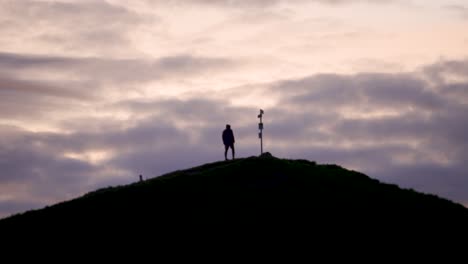 Hiker-arrives-at-mountain-peak-during-golden-hour