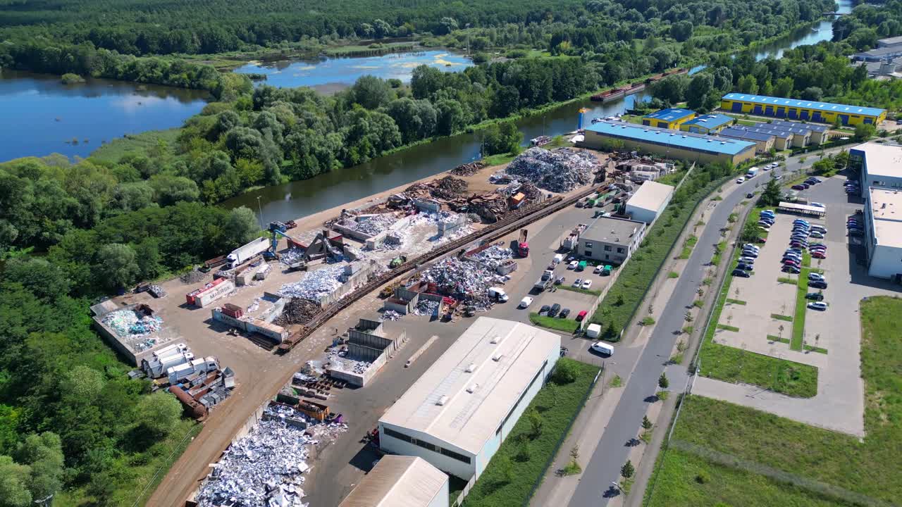 scrap metal recycling center managing waste and loading trucks, Hennigsdorf, Germany. Smooth aerial view flight drone top down Above view